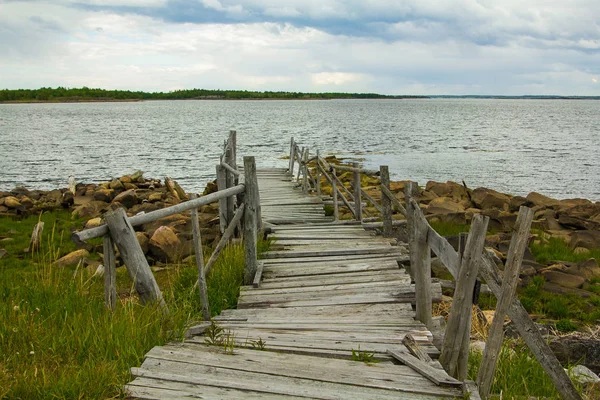 Vecchia passerella in legno verso il mare — Foto Stock