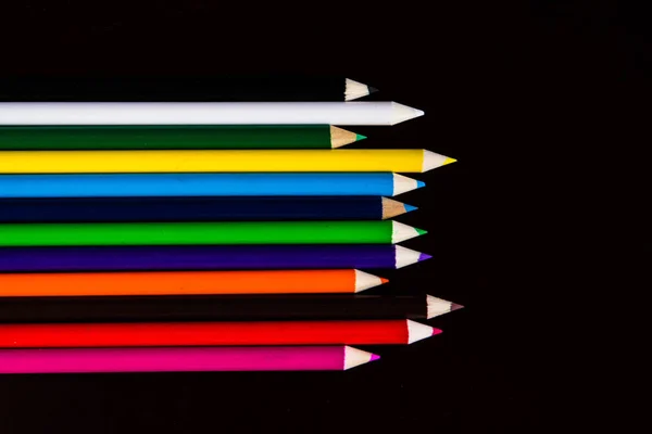 Barevné tužky leží na tmavém pozadí — Stock fotografie