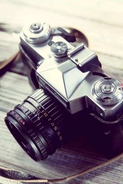 Retro Camera standing sideways on a wooden background — Stock Photo, Image