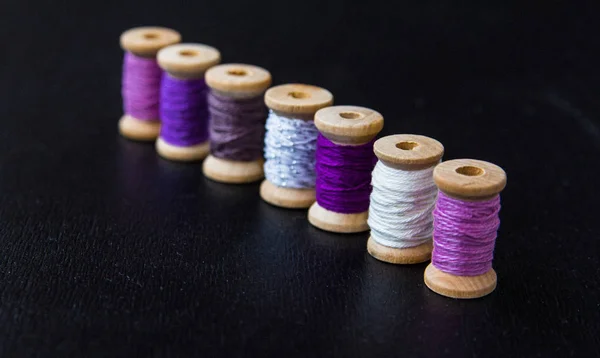 stock image wooden spools of thread of different colors standing diagonally 