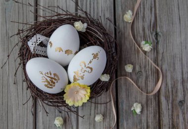 sepet içinde beyaz boyalı üç altın yumurta yalan