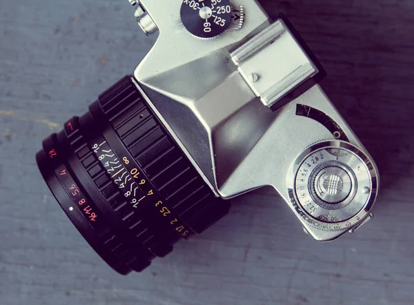 Retro Camera standing sideways on a wooden background — Stock Photo, Image