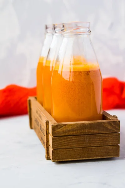 Botellas con zumo de naranja en una caja de madera — Foto de Stock