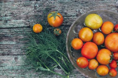 Ahşap arka plan üzerinde bir kapta domates