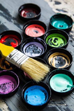 Gri bir arka plan üzerinde çok renkli boya yalanla kavanozlar için