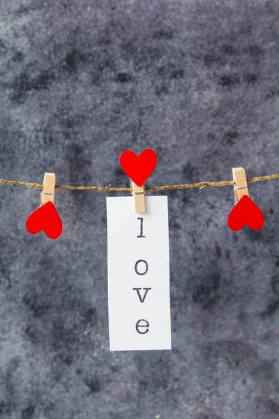 Beyaz kağıt clothespi bir iple asılı üzerinde yazıt aşk — Stok fotoğraf