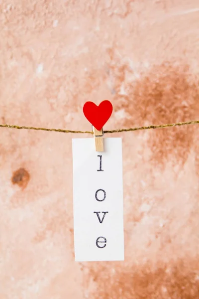 Napis miłość na białym papierze wiszące na sznurku z clothespi — Zdjęcie stockowe