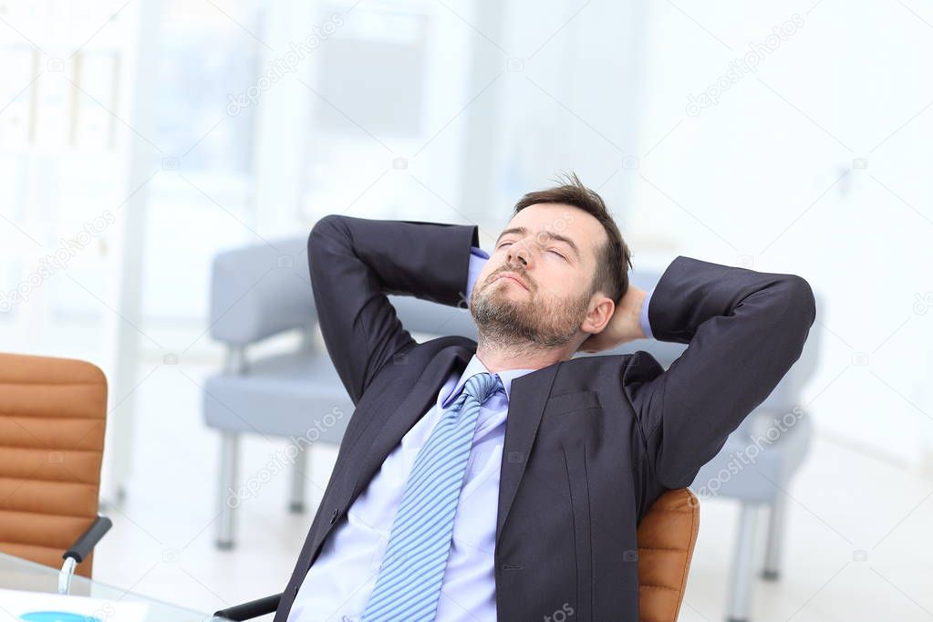 Satisfied businessman relaxing in his office