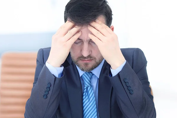 Feeling exhausted. Frustrated young beard man massaging his nose and keeping eyes closed while sitting at his working place in office — Stock Photo, Image