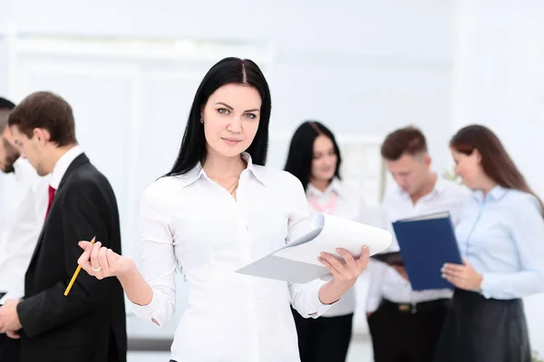 Glad affärskvinna med kollegor i bakgrunden — Stockfoto
