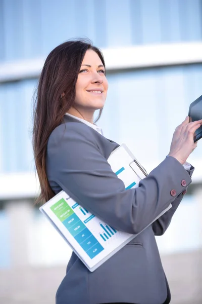 Zakenvrouw werken aan digitale tablet outdoor over gebouw achtergrond — Stockfoto