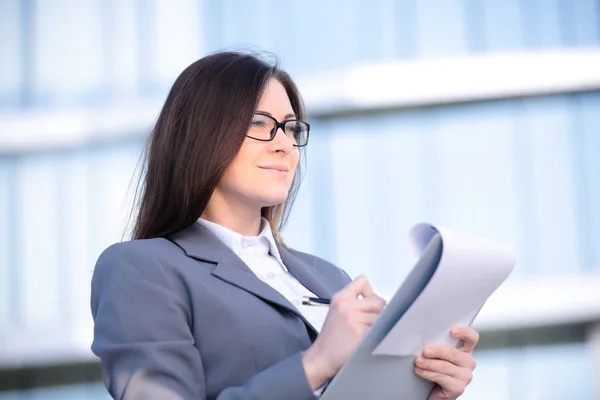 Businesswoman working on digital tablet outdoor over building background — Stock Photo, Image