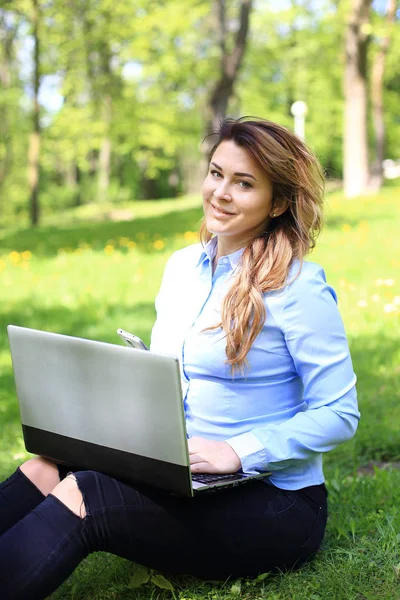 Jonge mooie meisje bezig met laptop buiten, liggend op gras, Kaukasische 20 jaar oud — Stockfoto