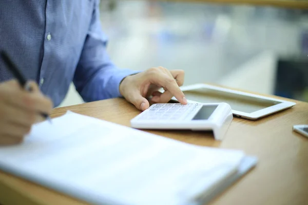 Man met behulp van de calculator voor graaf baten en resultaat. — Stockfoto