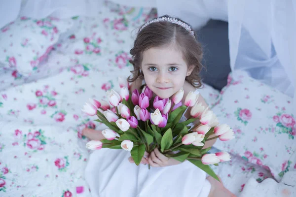Sevimli kız bahar çiçekleri tutarak — Stok fotoğraf