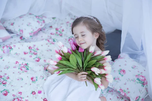 Cute girl holding spring flowers — Stock Photo, Image