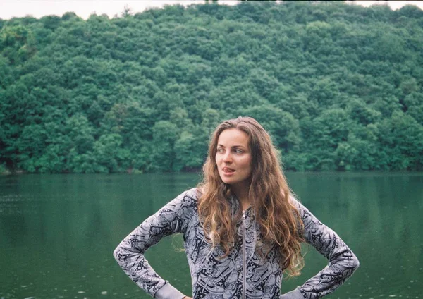 Donna nella foresta con lago Foto Stock