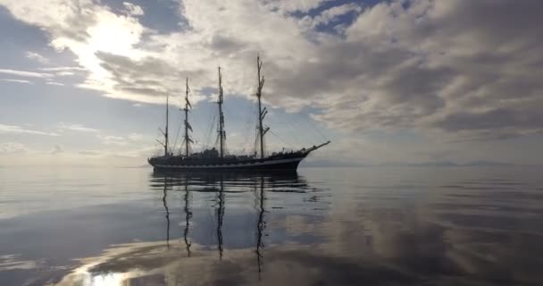 Statek żaglowy. Stary czterokalczasty Barque w spokojnym lustro-gładkie morze na tle wybrzeża górskiego. — Wideo stockowe