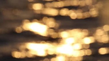 Blurred Sun Glare Reflections On The Ocean Water Surface. Golden Cinematic Boke