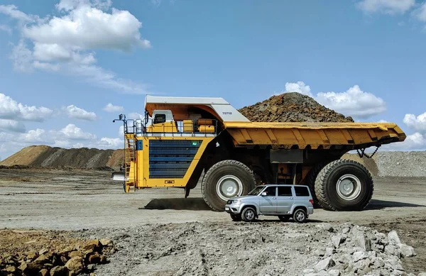 石炭採掘地域とUaz Patriott Suvで世界最大かつ最大のBelazダンプトラック ストック写真
