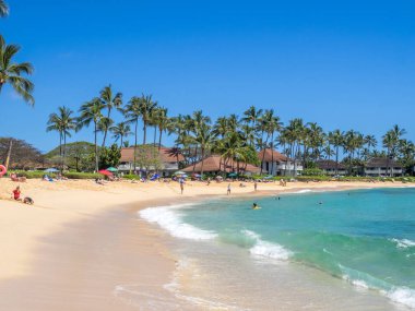 ourists and locals enjoy Poipu Beach clipart