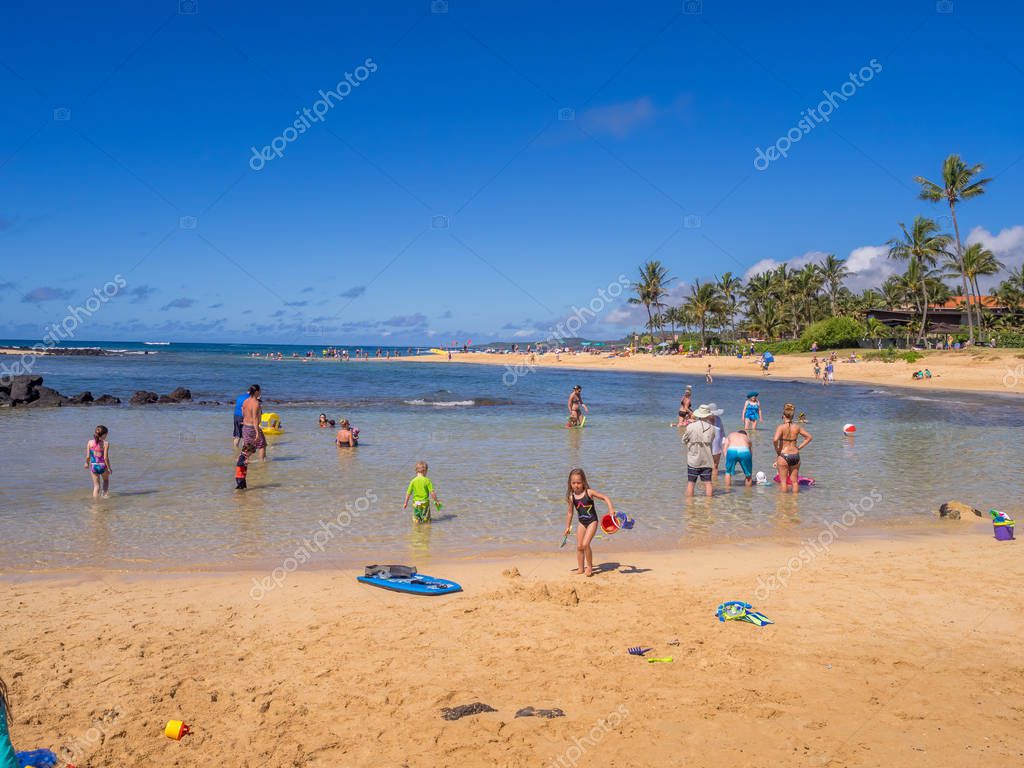 turistas y lugareños disfrutan de Poipu Beach 2023