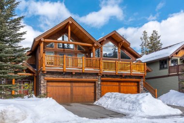 Luxury homes in the town of Canmore Alberta during the winter. Canmore is a popular resort community outside Banff National Park. clipart