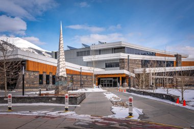 Canmore, Alberta - 4 Nisan 2020: Canmore 'un dinlenme merkezi Yükseliş Yeri' nin dış cephesine güzel bir kış gününde bakmak. 