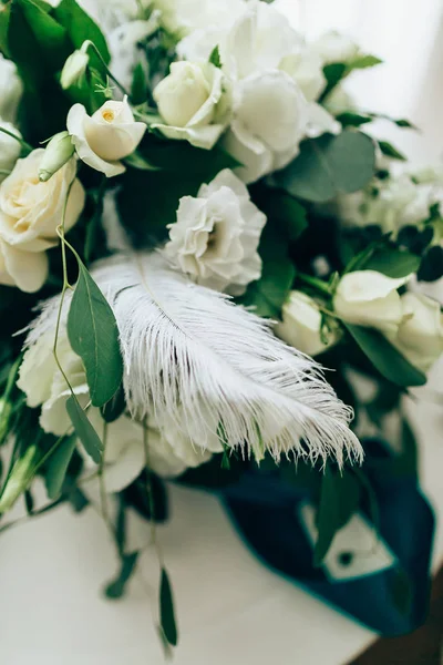 Romantische florale Komposition mit Rosen und Federn auf dem Tisch. Nahaufnahme. — Stockfoto