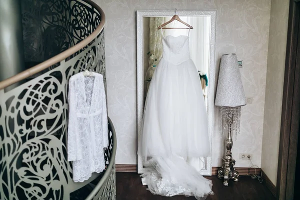 Güzel düğün sabahlığı ve bir askı elbise. Portre, iç.