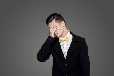 Trendy delikanlı. Siyah Süiti, sarı papyon, gri arka plan. Portre