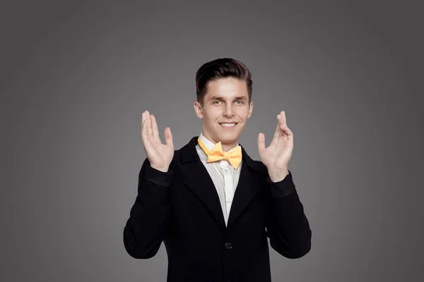 Joven hombre de moda. Suite negra, corbata amarilla, fondo gris. Retrato —  Fotos de Stock