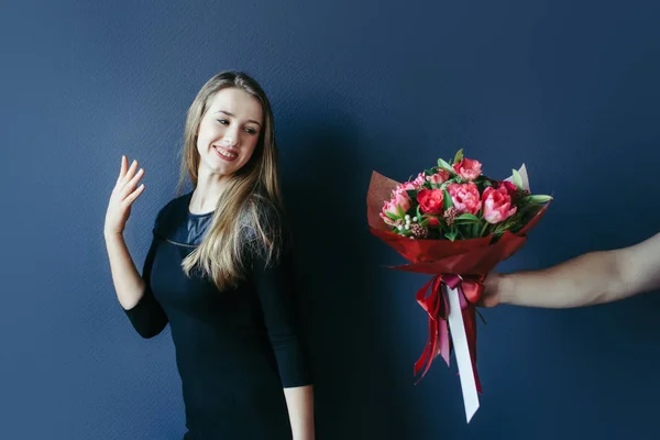 Schattig meisje krijgen boeket van rode tulpen. Vriendje geeft tulpen. — Stockfoto