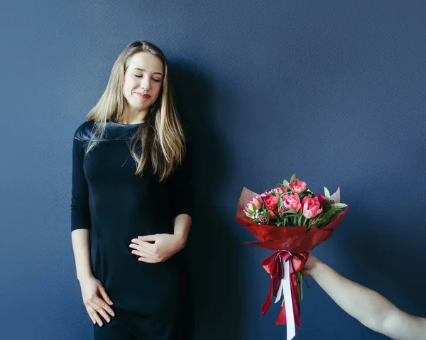 Schattig meisje krijgen boeket van rode tulpen. Vriendje geeft tulpen. — Stockfoto