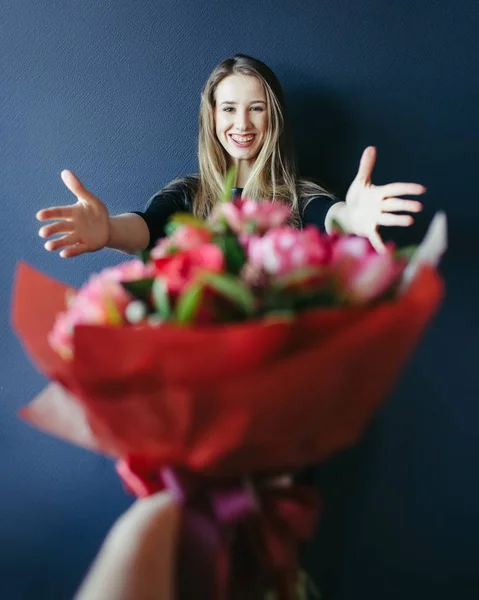 Schattig meisje krijgen boeket van rode tulpen. Vriendje geeft tulpen. — Stockfoto