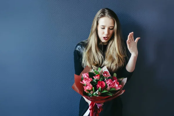 Schattig meisje met boeket van rode tulpen. — Stockfoto