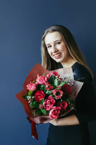 Schattig meisje met boeket van rode tulpen. — Stockfoto