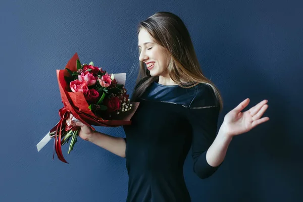 Schattig meisje met boeket van rode tulpen. — Stockfoto