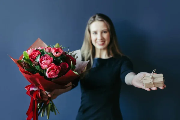 赤いチューリップおよび女の子の手で驚きの woodenbox の花束. — ストック写真