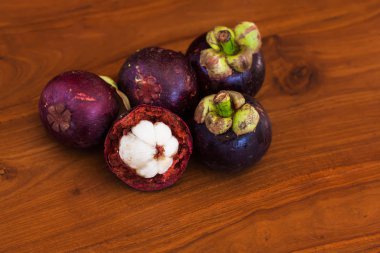 Ahşap kahverengi masa üzerinde beş taze mangosteens