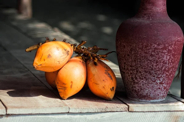 Bunch of mangoes with tyrian purple clay on wooden floor — Stock Photo, Image
