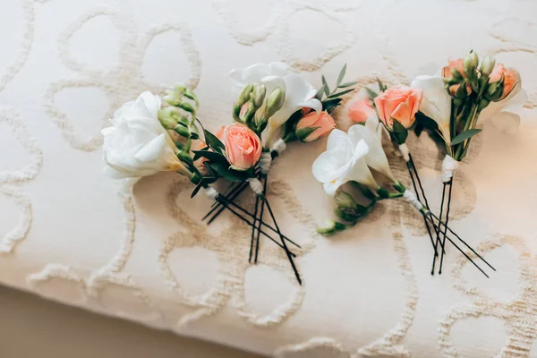 Boeketten van witte lelies en perzik rozen op bed — Stockfoto