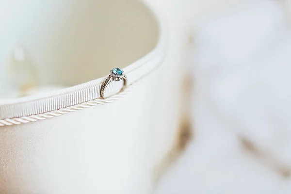 Изумрудное кольцо, стоящее на стороне текстильной коробки — стоковое фото