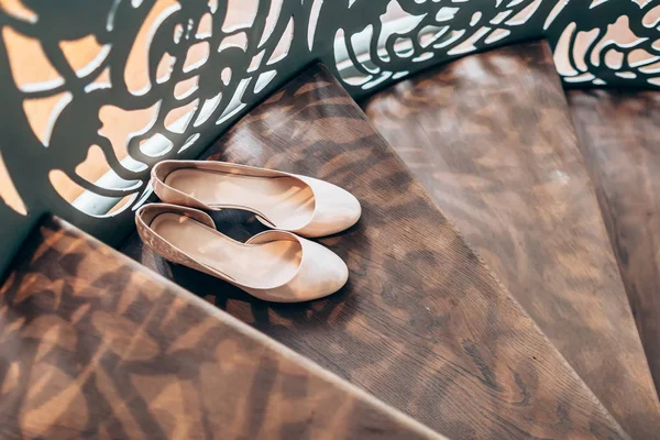 Zapatos de boda para mujer melocotón en escaleras de madera con barandillas derativas — Foto de Stock