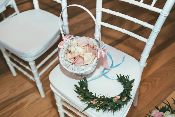 Cesta com pétalas de rosa na cadeira branca na cerimônia de casamento — Fotografia de Stock