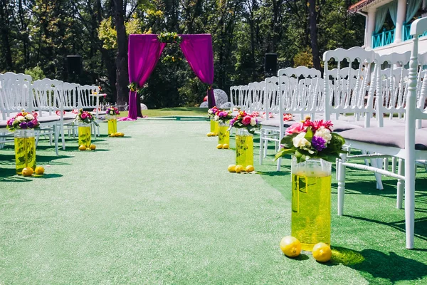 Красивая свадебная арка со стульями с каждой стороны — стоковое фото
