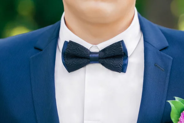 Black-and-blue bow-tie on grooms neck — Stock Photo, Image