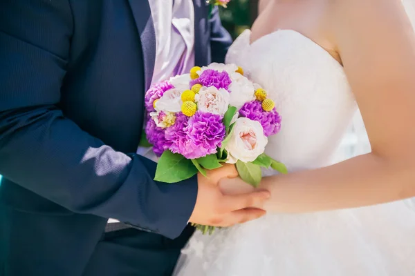 Recém-casados segurando delicado buquê de casamento — Fotografia de Stock