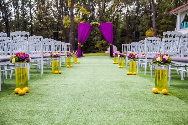 Krásné svatební oblouk s židlemi na na obou stranách — Stock fotografie