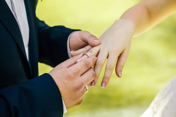 Recém-casados que ficam de braço dado, com alianças de casamento — Fotografia de Stock